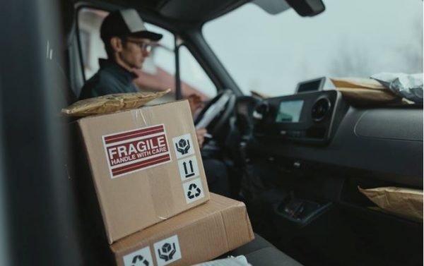 A box of a fragile item sitting in the front seat of a delivery truck