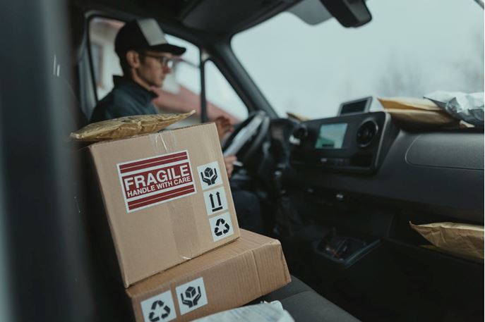 A box of a fragile item sitting in the front seat of a delivery truck